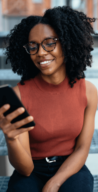 woman smiling looking at her phone